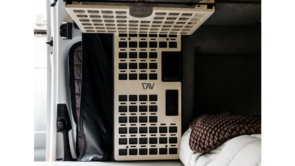 Storyteller CAV MOLLE panel mounted in van interior above bedding and storage area