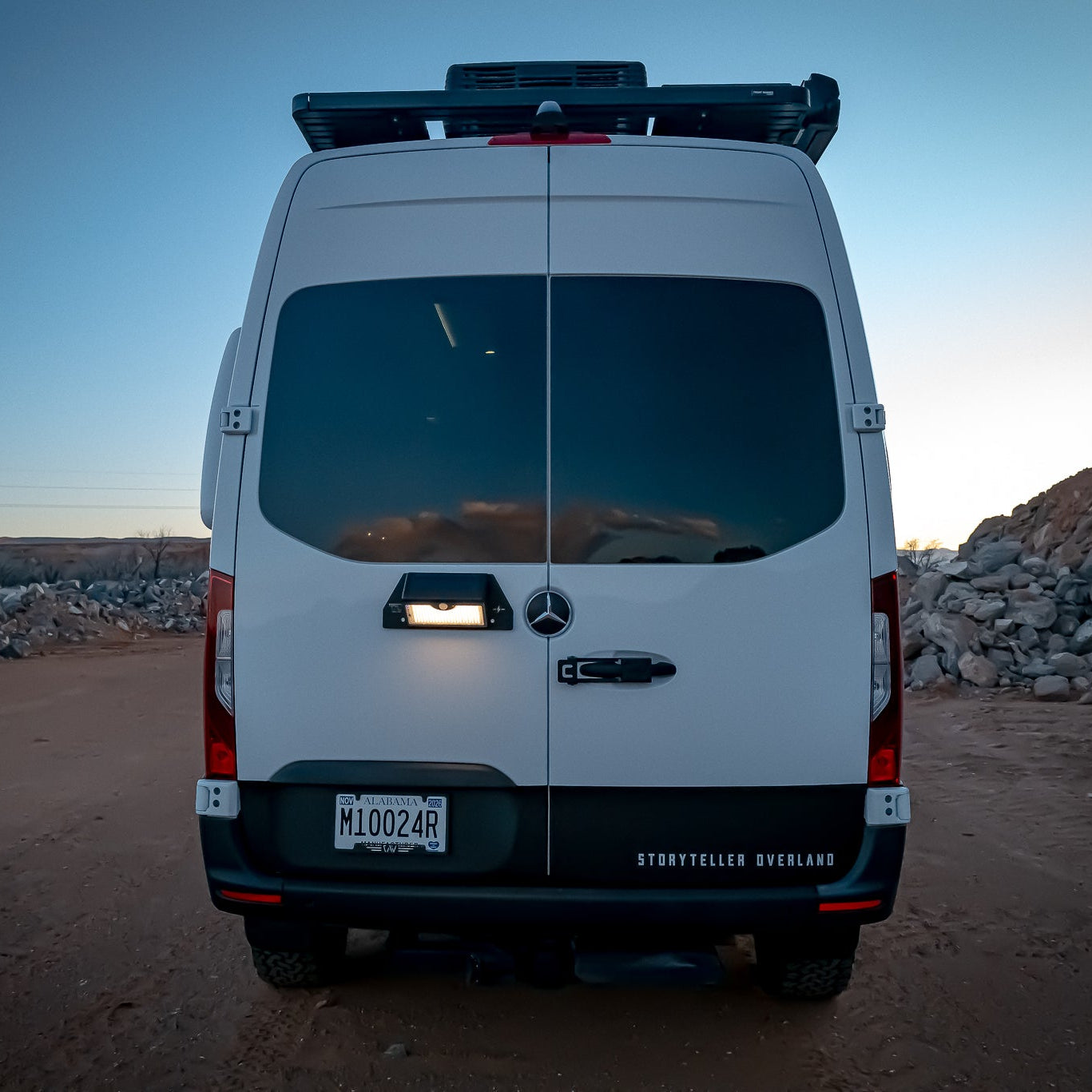Back view of a white sprinter van in a showing illuminated portable magnetic solar motion sensor light
