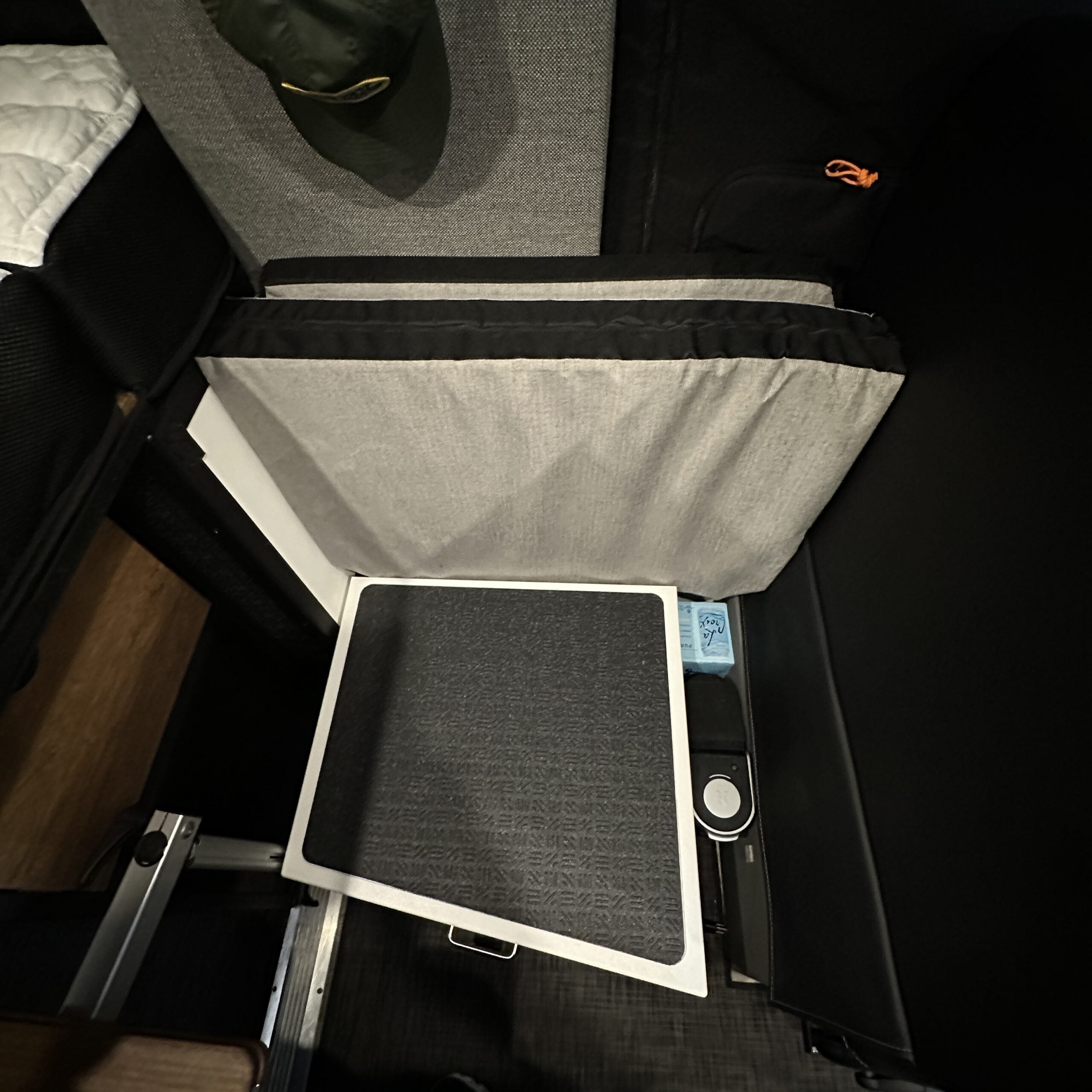 Groove Lounge Mattress Topper for the Storyteller folded behind seat in van interior.