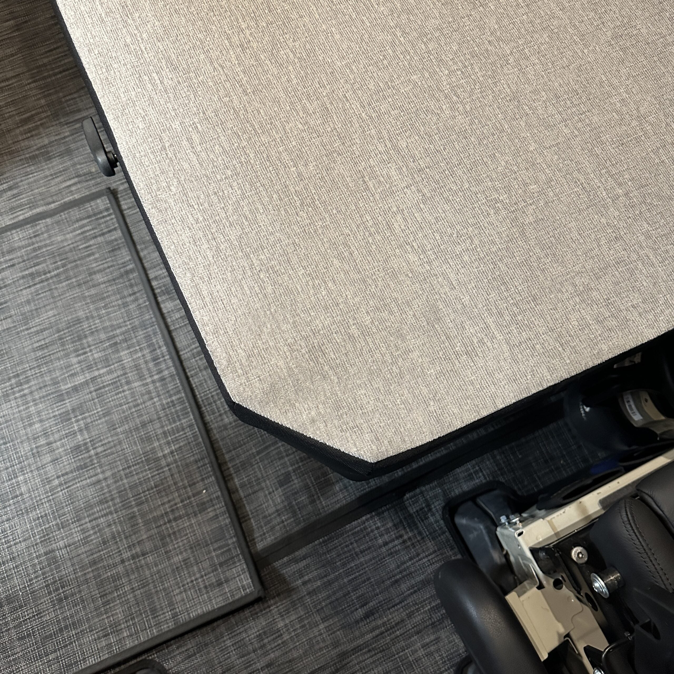 Close-up of Groove Lounge Mattress Topper for the Storyteller van, showing angled corner and textured fabric.