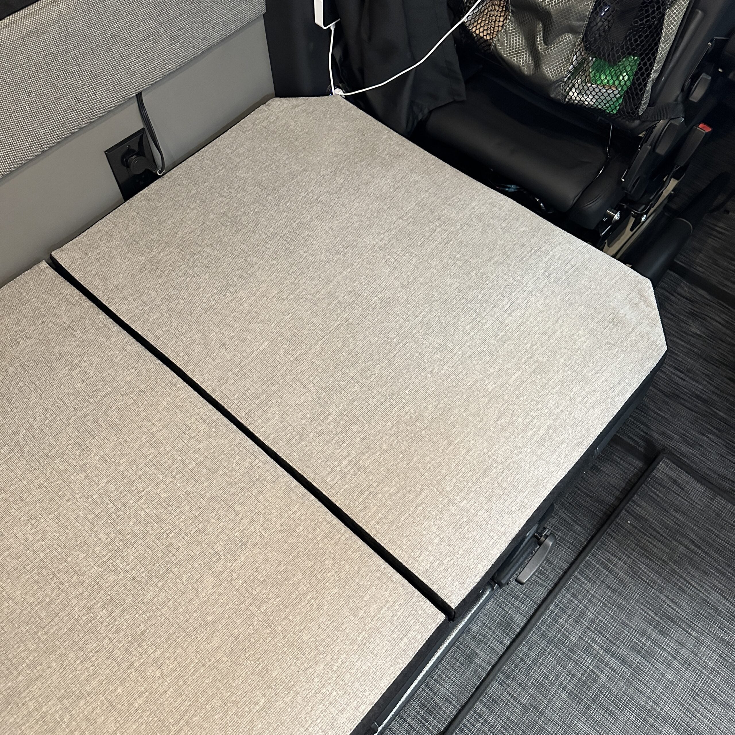Groove Lounge Mattress Topper laid flat across van seating area, showing fitted cushions in neutral fabric.