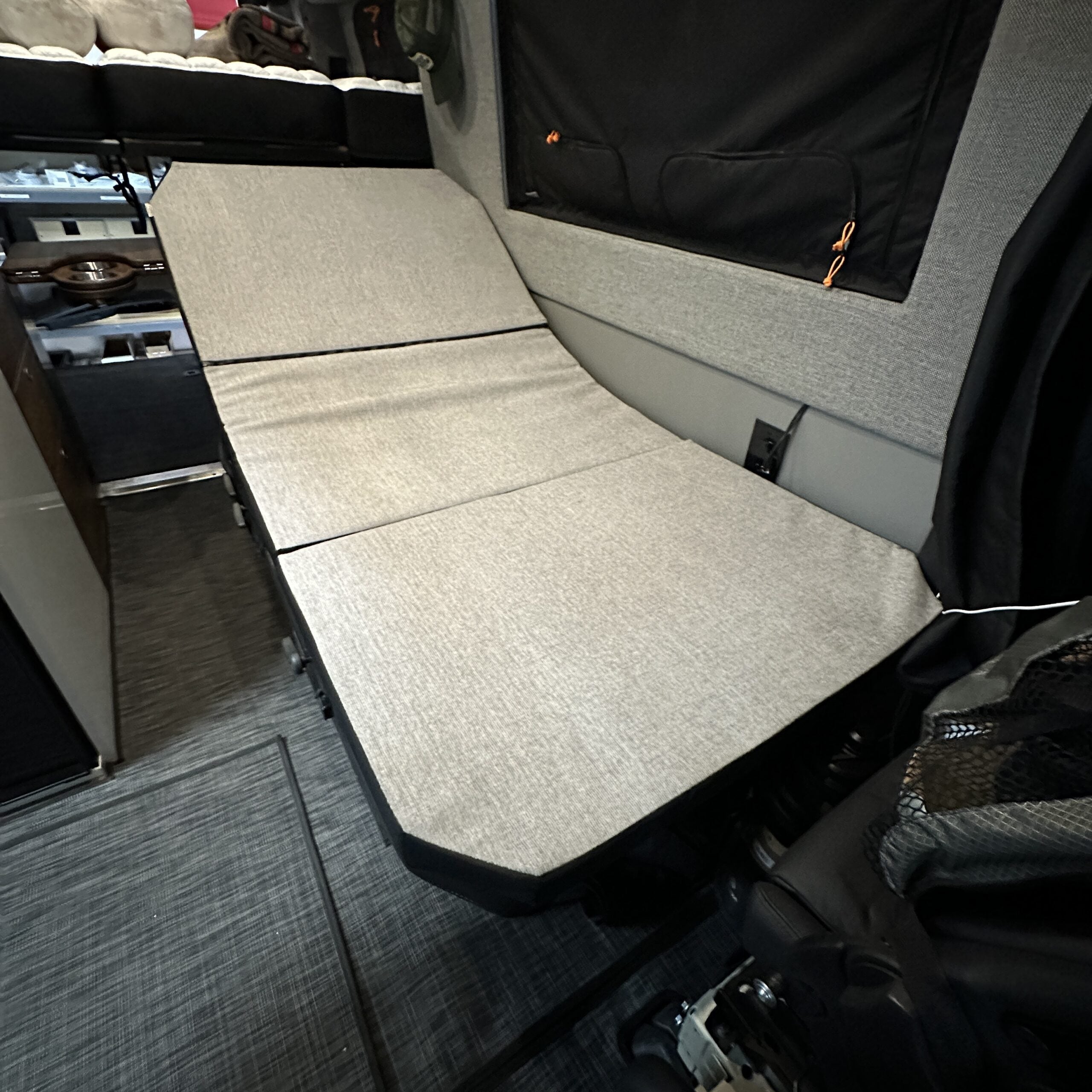 Groove Lounge Mattress Topper by Revel set up inside a Storyteller van interior seating area