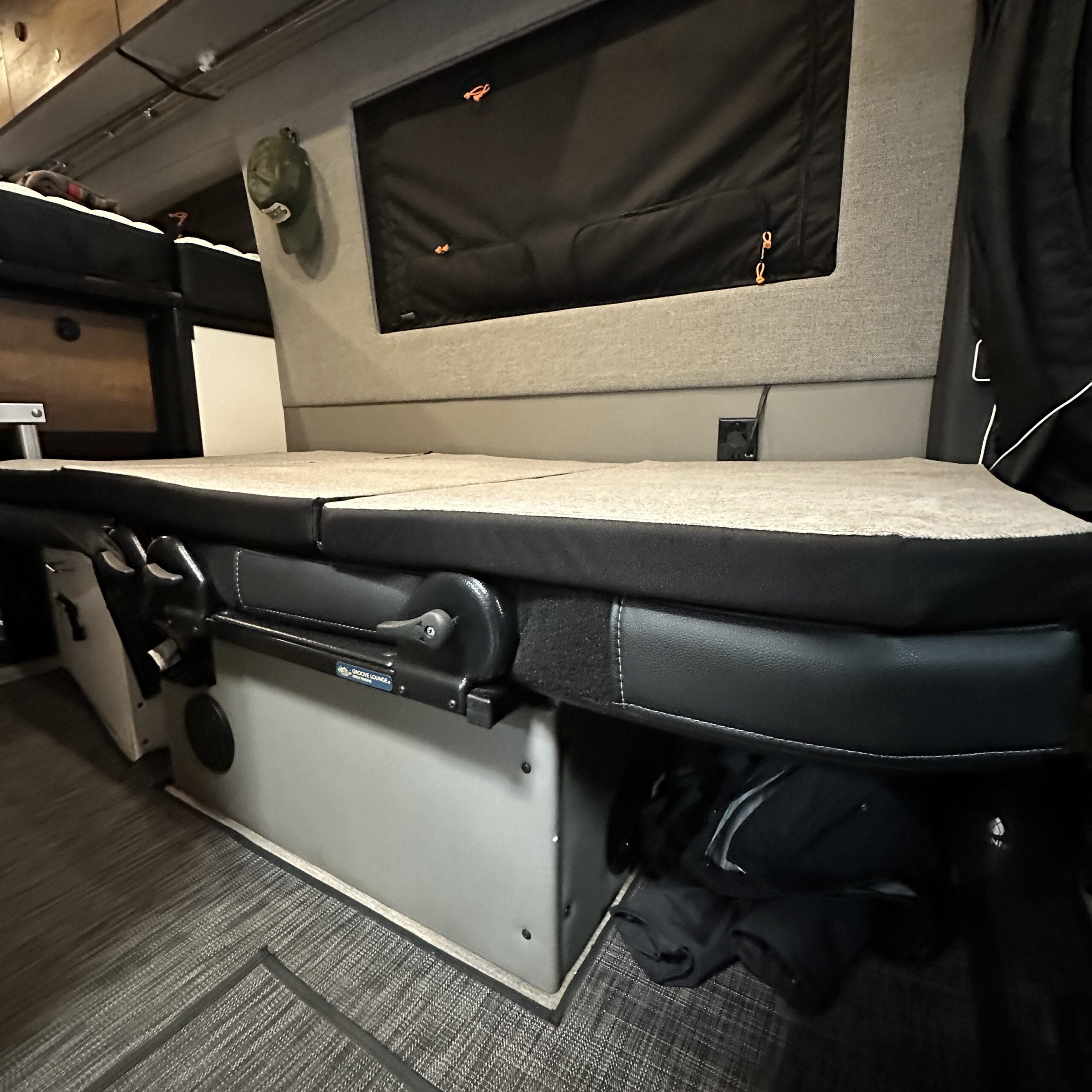Groove Lounge Mattress Topper for Storyteller van, laid flat on folded bench seat in modern van interior.