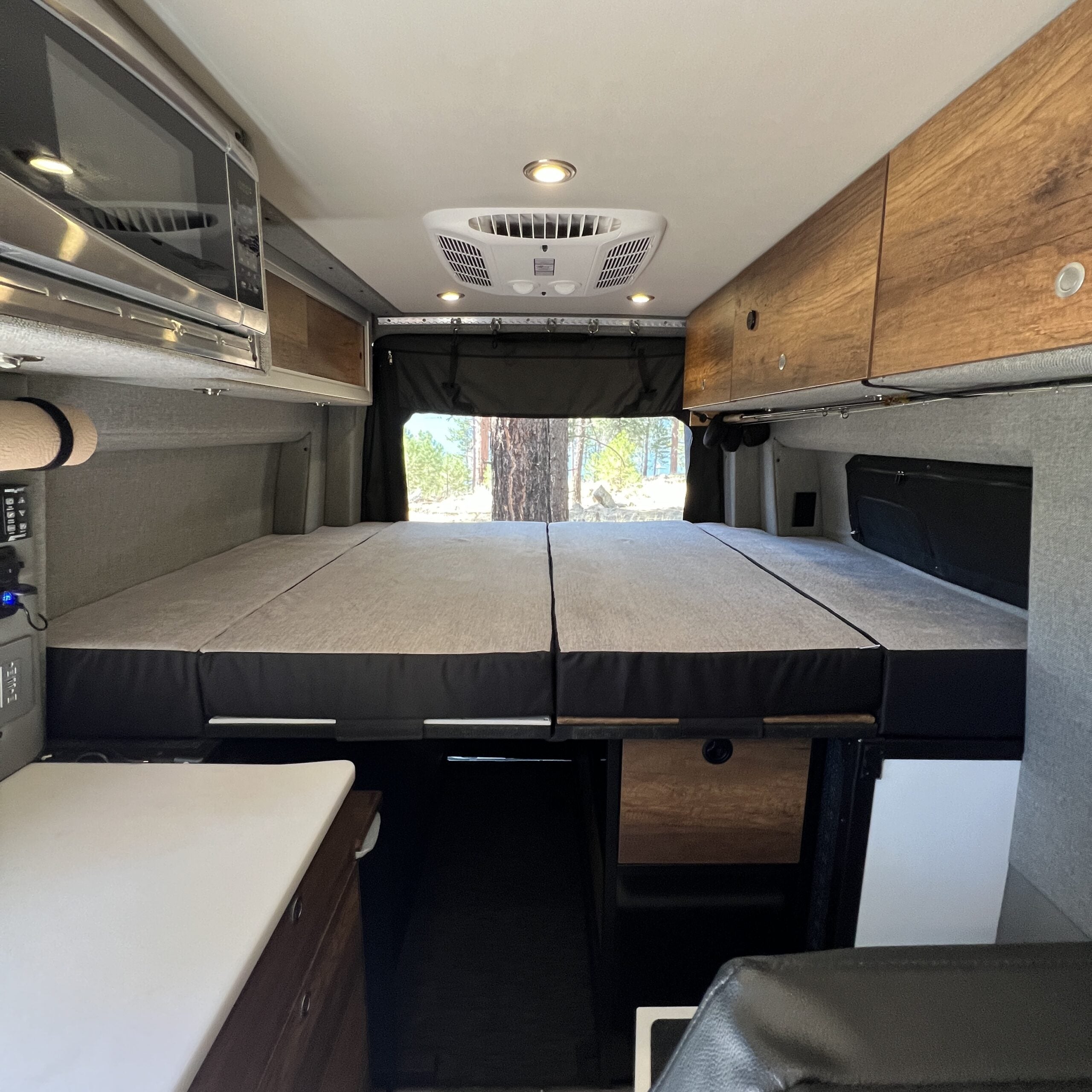 Luxe5 Cooling Memory Foam 5-inch mattress set up as a bed in the rear of a Storyteller MODE van.