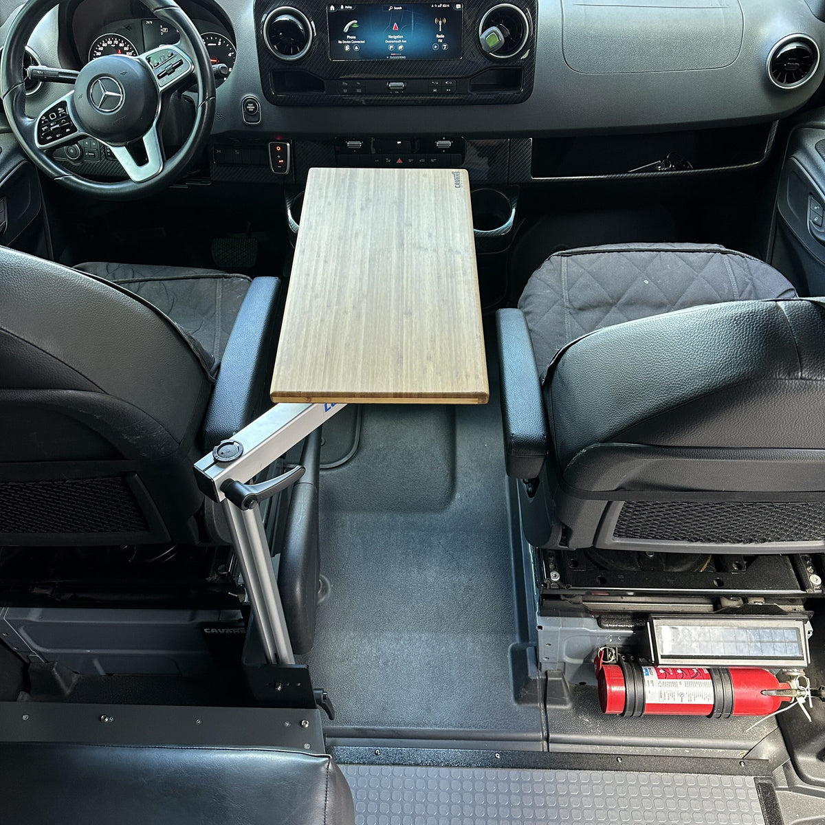 table mount Long Leg Pro Series table installed between front seats in a van cockpit with black interior.