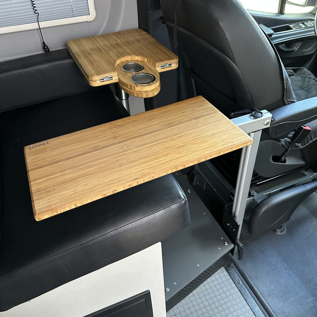 CAV table mount Long Leg bamboo table mounted in a van interior next to a passenger seat.