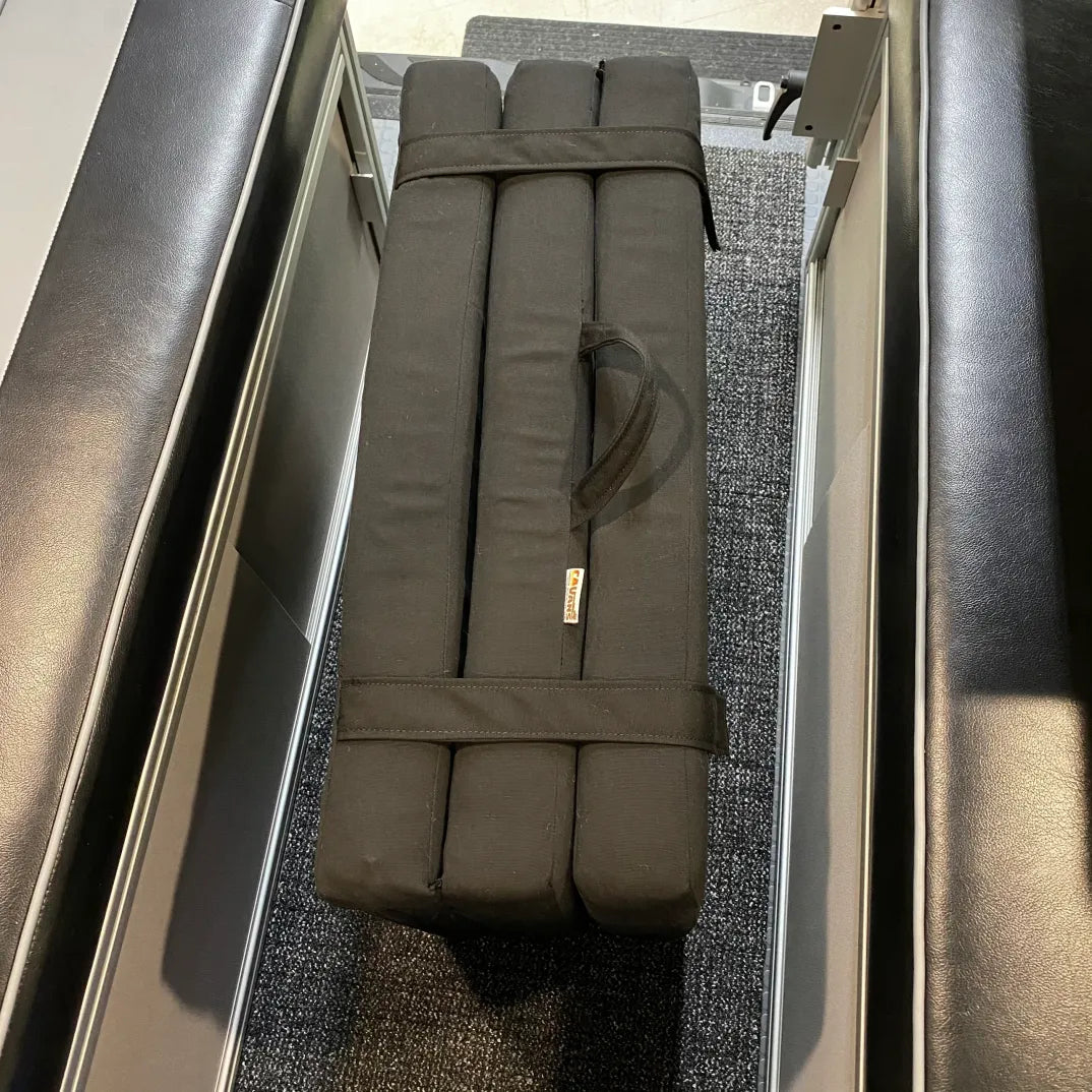 Folded Revel floor mattress with handle stored between van bench seats.