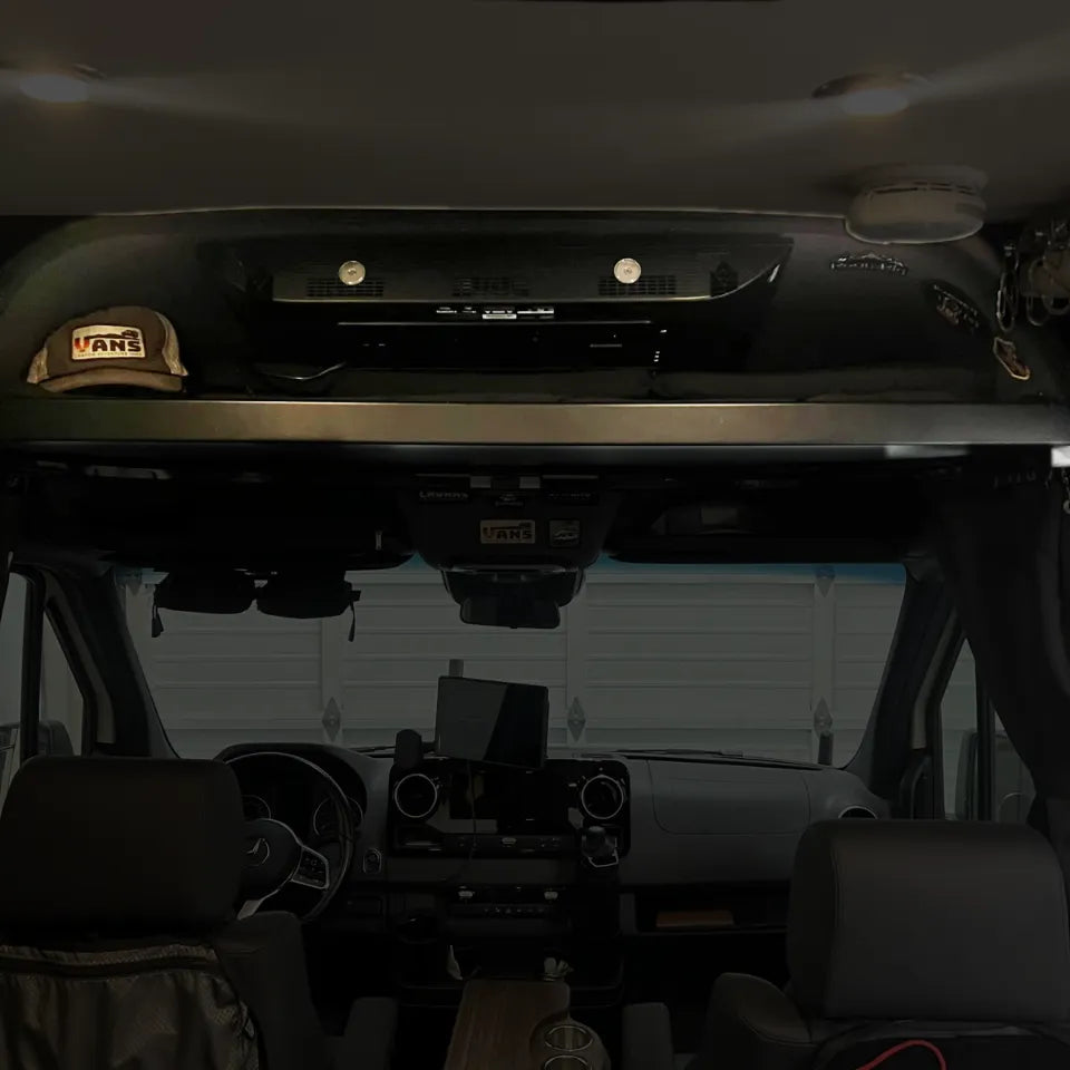 OLD CAV cab headliner shelf installed in a 2019+ Mercedes Sprinter van interior with storage items.