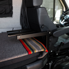 Canyon Table Leg System by GH1 mounted beside van seat with folded bed platform and blanket.