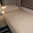 Ultra Luxe mattress inside Winnebago Ekko van with beige bedding and side window shade.