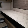 Ultra Luxe mattress in a Winnebago Ekko van with wood cabinets and a quilted wall shade.