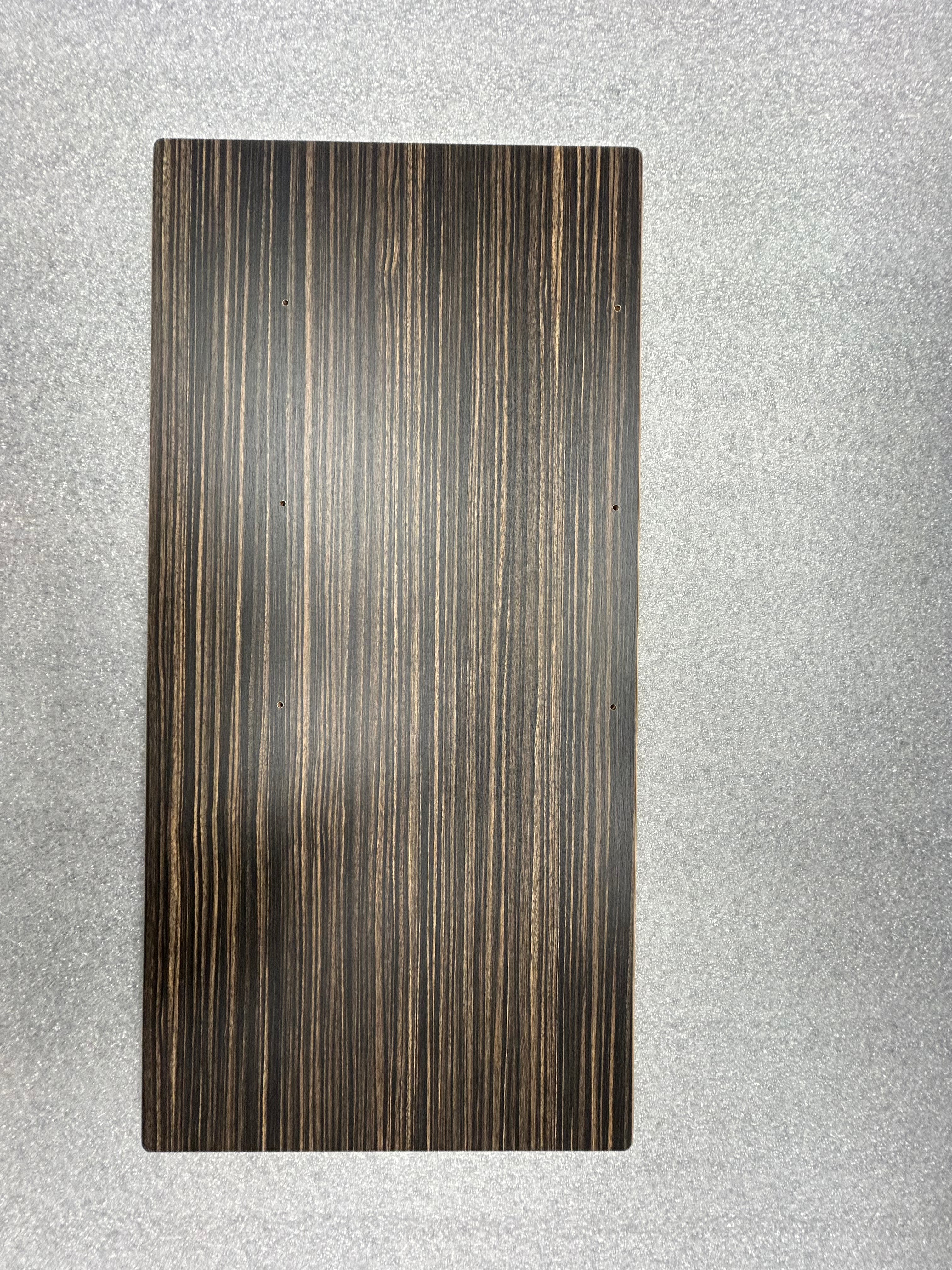 Small rectangular tabletop with dark woodgrain finish on a gray surface.