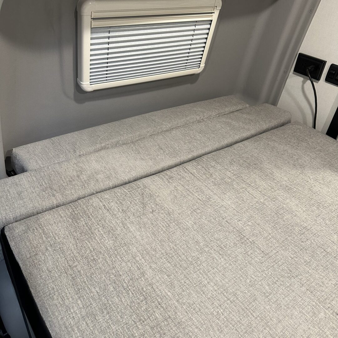 Luxe6 memory foam 6-inch mattress laid flat inside a van interior with light gray upholstery.