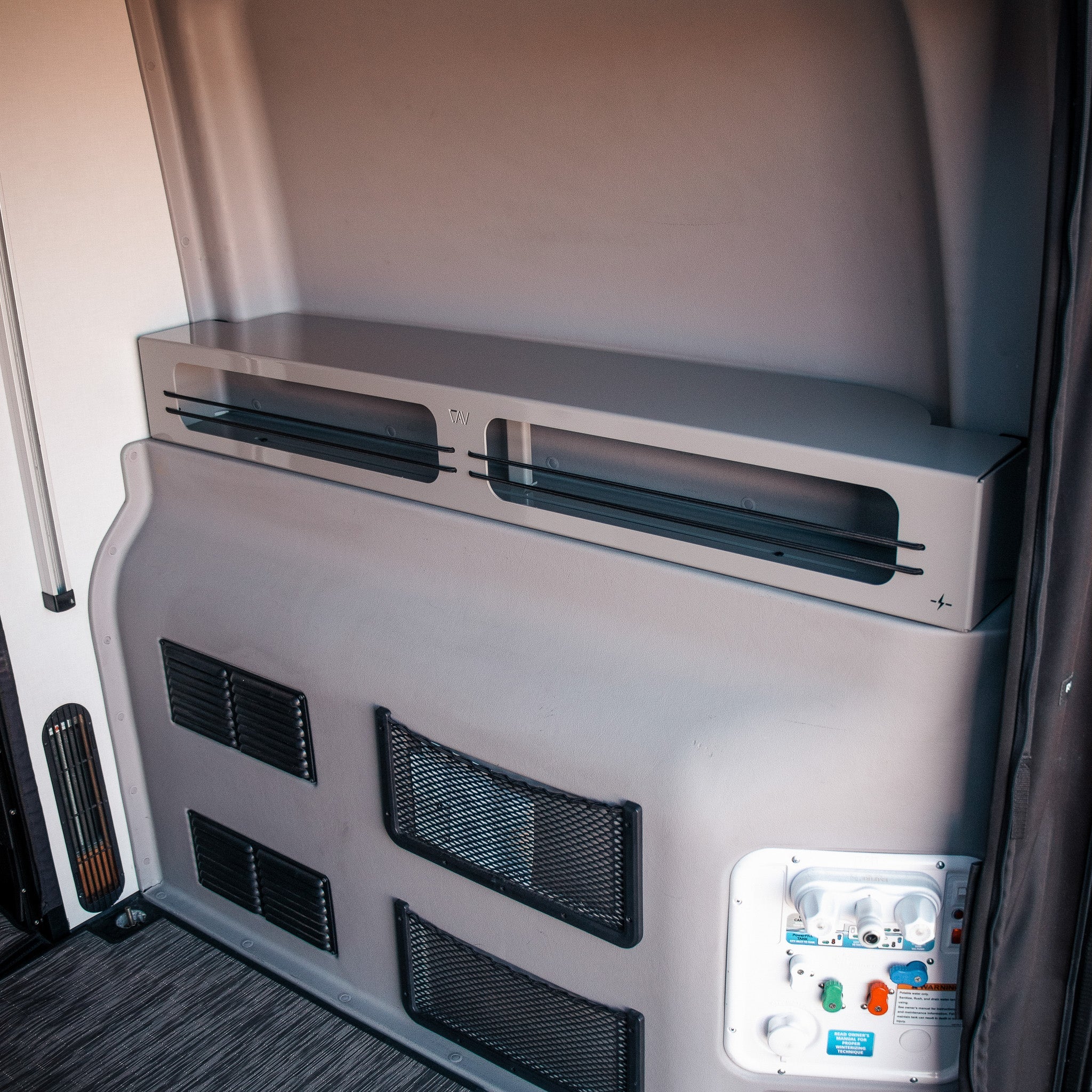 Grey Revel 6-inch bed risers installed in the rear corner of a van interior.