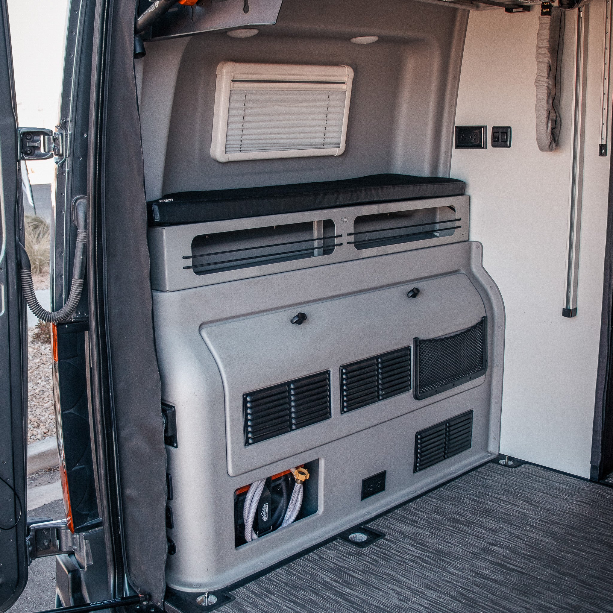 Revel 2 Bed Riser Pro Bed Bolsters installed in rear van interior with storage and vent access visible
