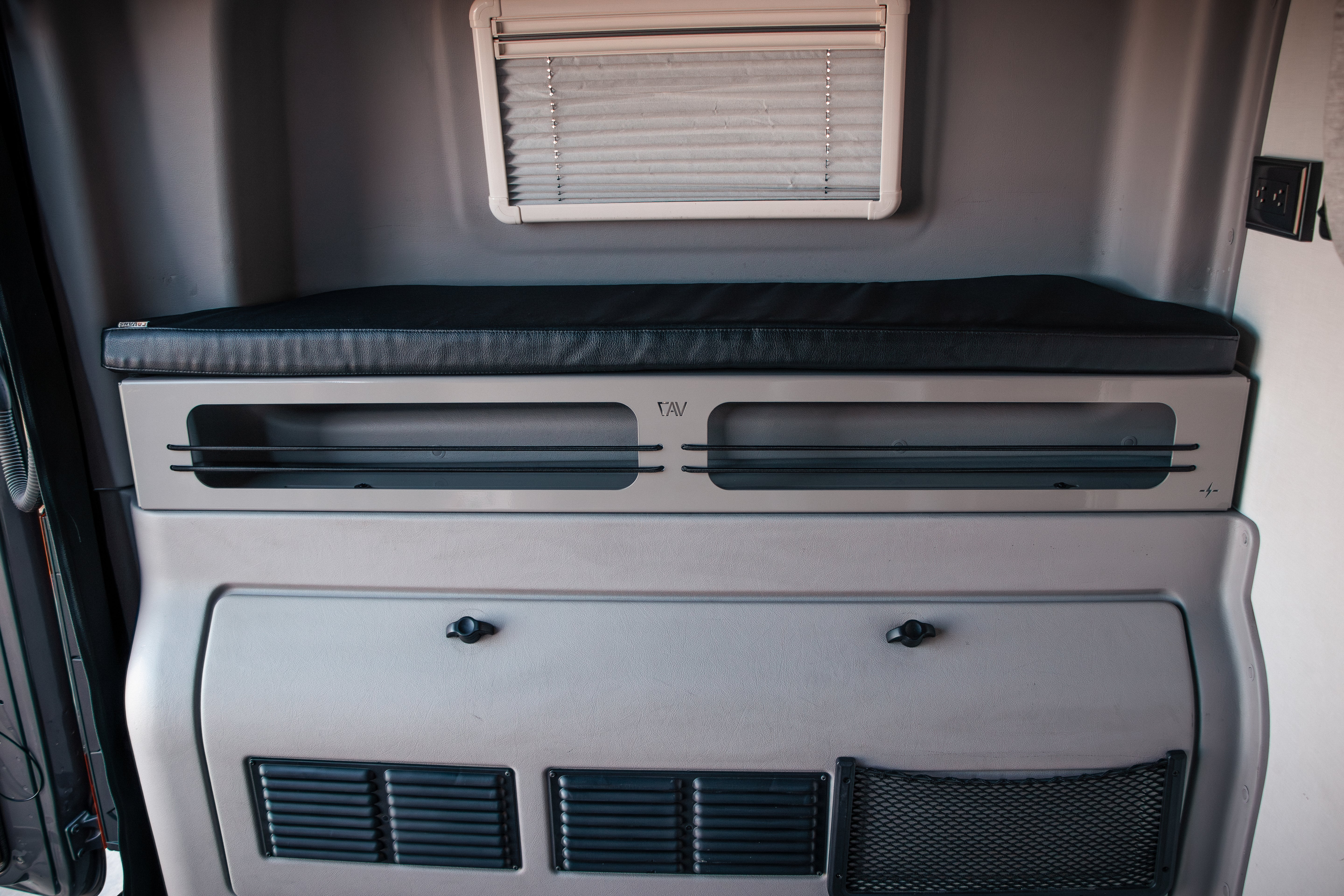 Revel 6-inch bed risers installed under foldaway sleeping platform in van interior.