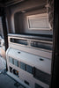 Interior view of a Revel van with 6-inch bed risers installed below the sleeping platform.