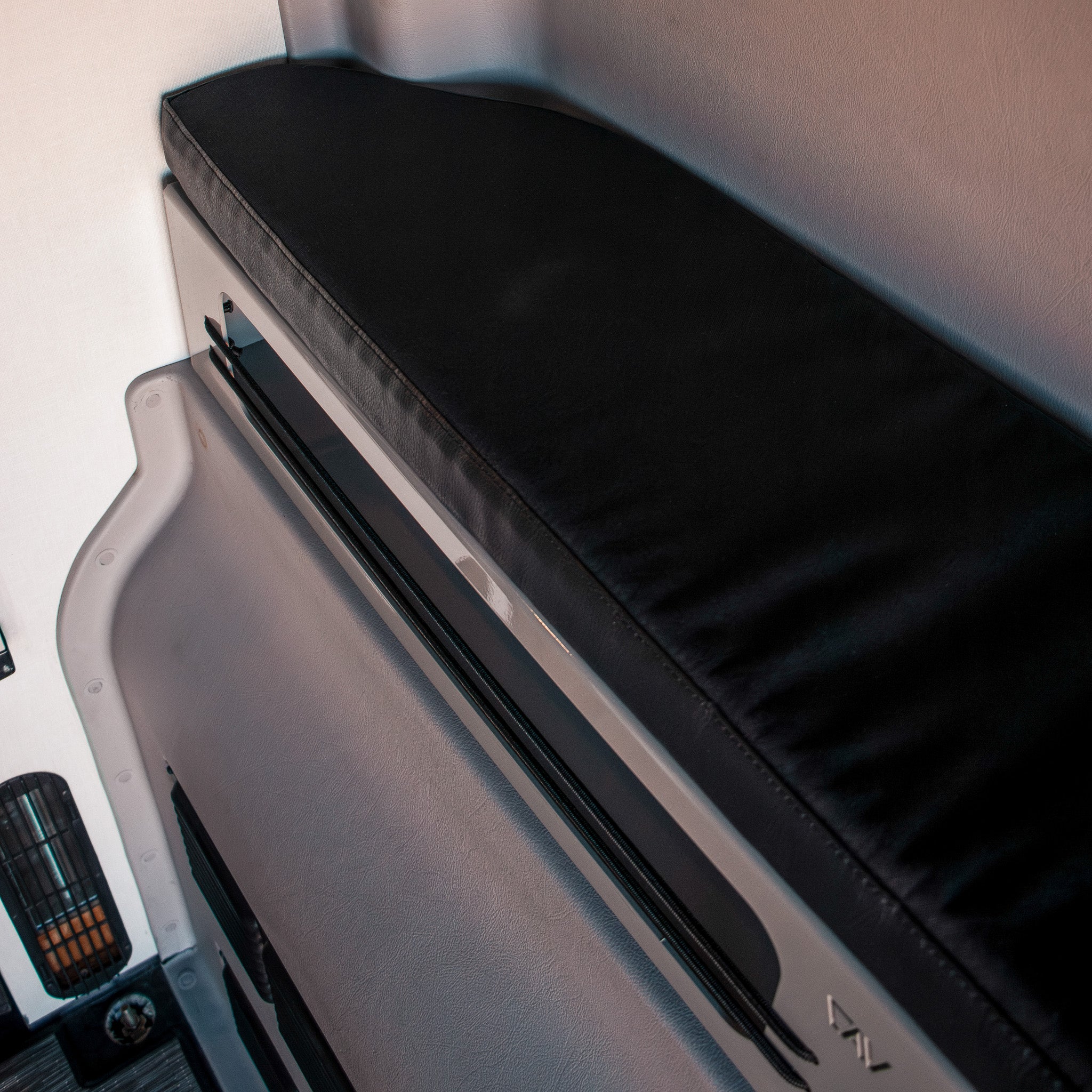 Black 2-inch Pro Bed Bolster installed along van wall for added sleeping support