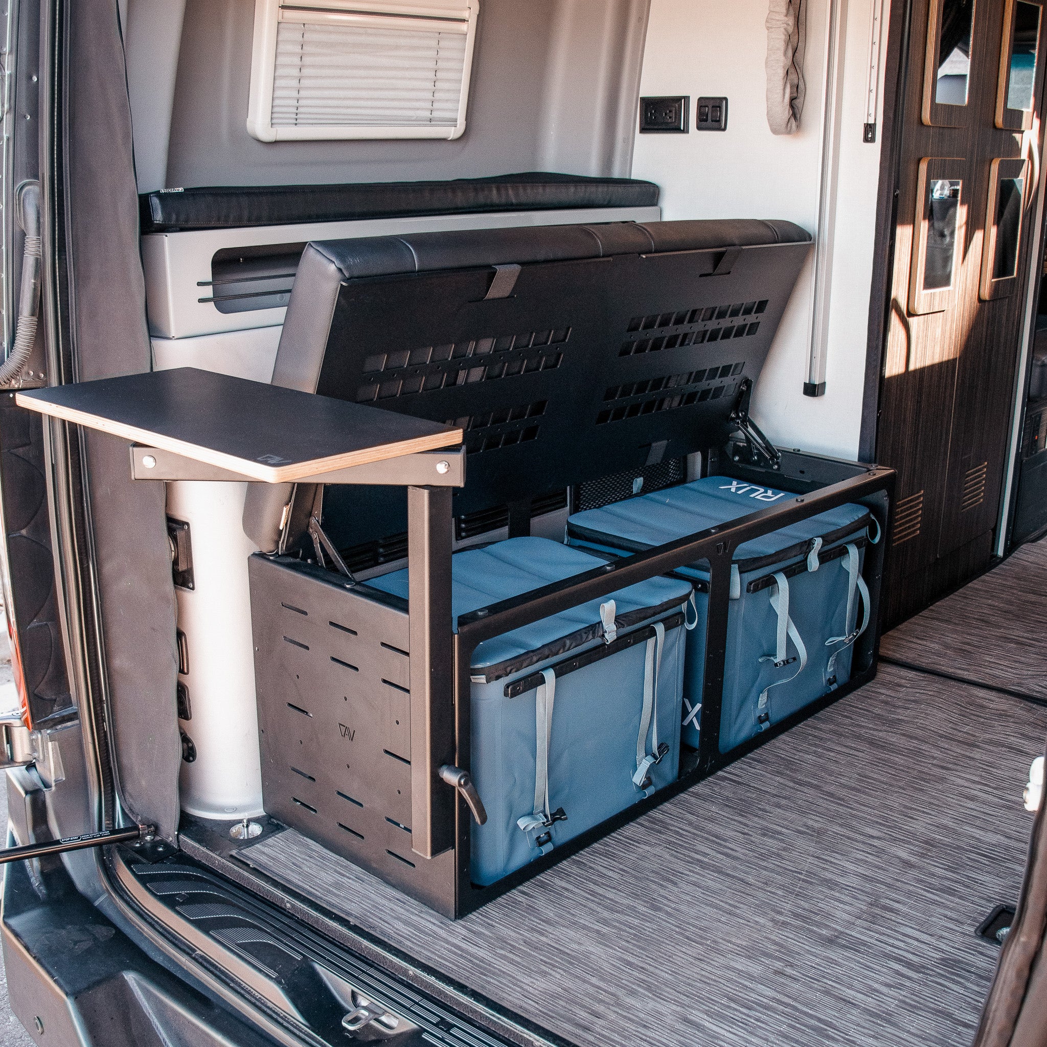 GLSS Rux system with open storage bench and two blue gear bags inside a van interior