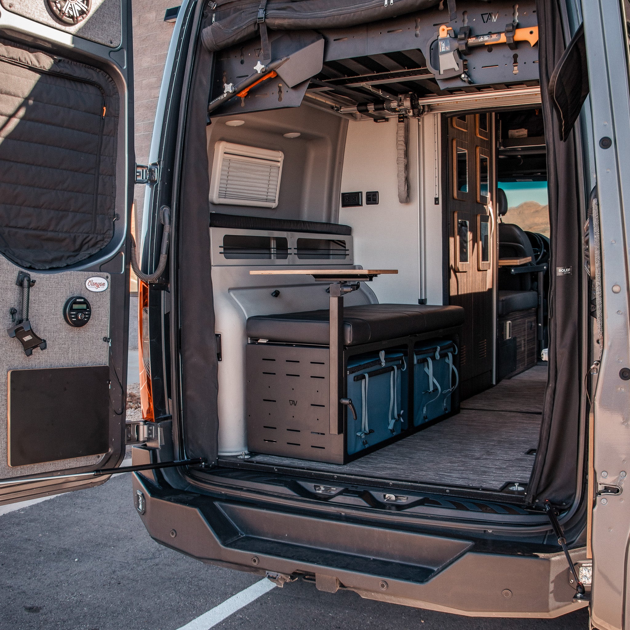 Interior view of GLSS Rux van with foldable table, storage drawers, and seating benches.