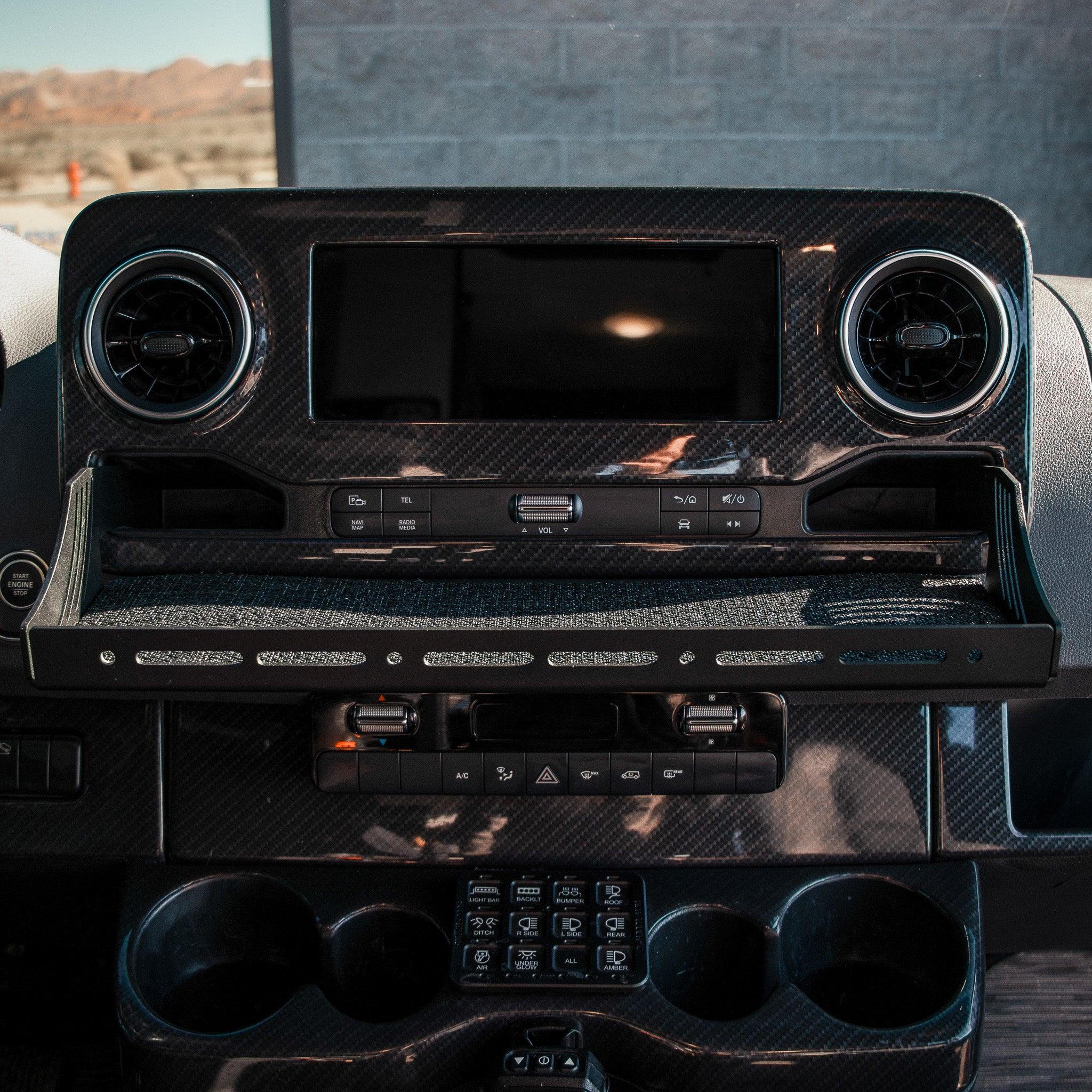 CAV D-ash Tray Pro installed in van dashboard with black carbon fiber finish and organized console space.