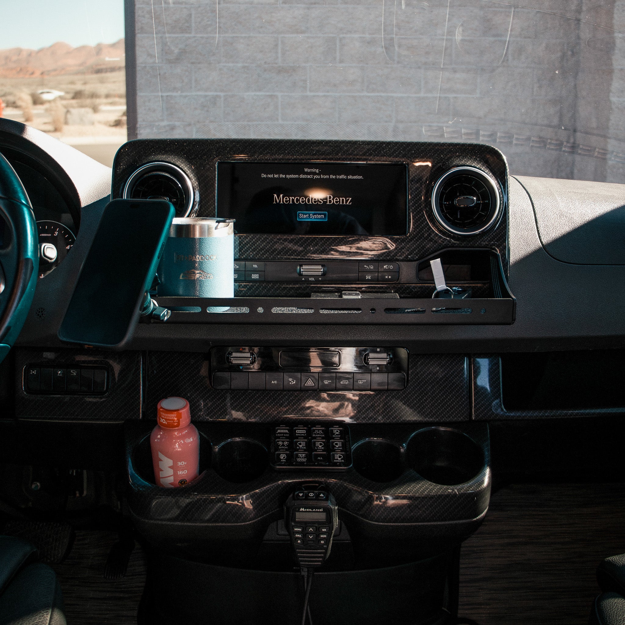 CAV D-ash Tray Pro installed in a van dashboard with drinks, phone, and mug organized.