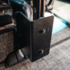Close-up of a black metal console table bracket mounted inside a van near the drivers seat.