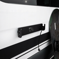 CAV magnetic ski and snowboard holder mounted on van exterior with a snowboard leaning nearby