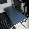 Large Universal Table Top installed between van seats with dark blue surface and edge detail.