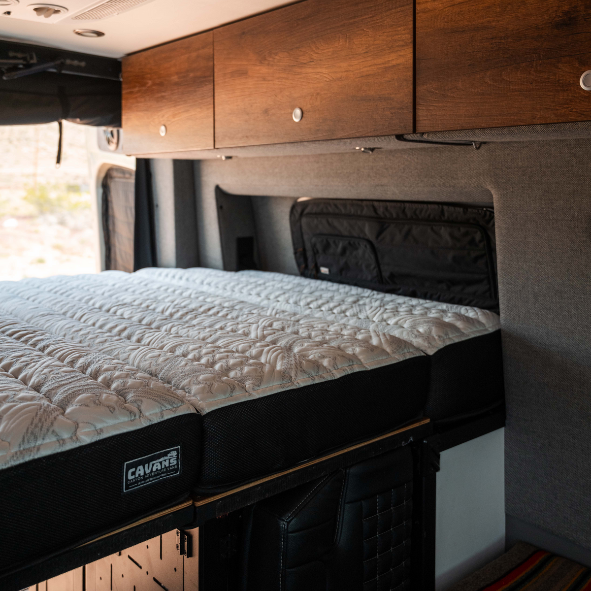 CAVAN ultra luxe mattress in a Storyteller Overland MODE van interior with wood cabinetry