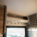 GH1 doorway upper cabinet with smoked acrylic door mounted above van entryway.