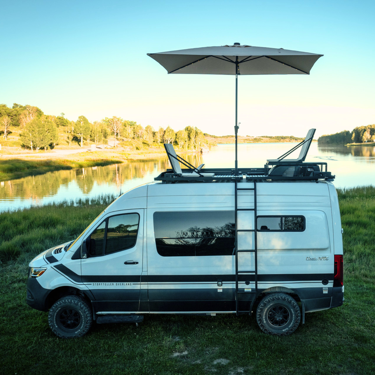 Storyteller Overland rooftop seating system mounted to front runner roof rack sprinter van parked by lake