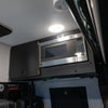 Tiffin GH1 microwave kit installed in upper van cabinet with stainless steel microwave.