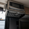 STO Undercabinet Shelf mounted below a microwave in a van interior.