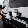 Magnetic outdoor utility shelf with paper towels and storage cups attached to side of black and white van.