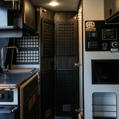 Canyon Universal MOLLE Panel mounted on interior van cabinet door with dark wood finish.