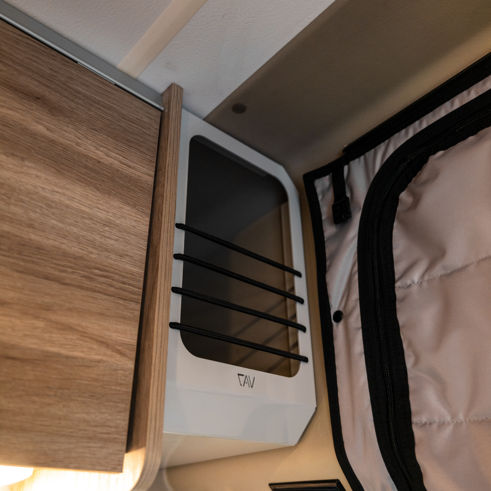 CAV Ekko Cab Cubby mounted inside van near overhead cabinet and insulated door.