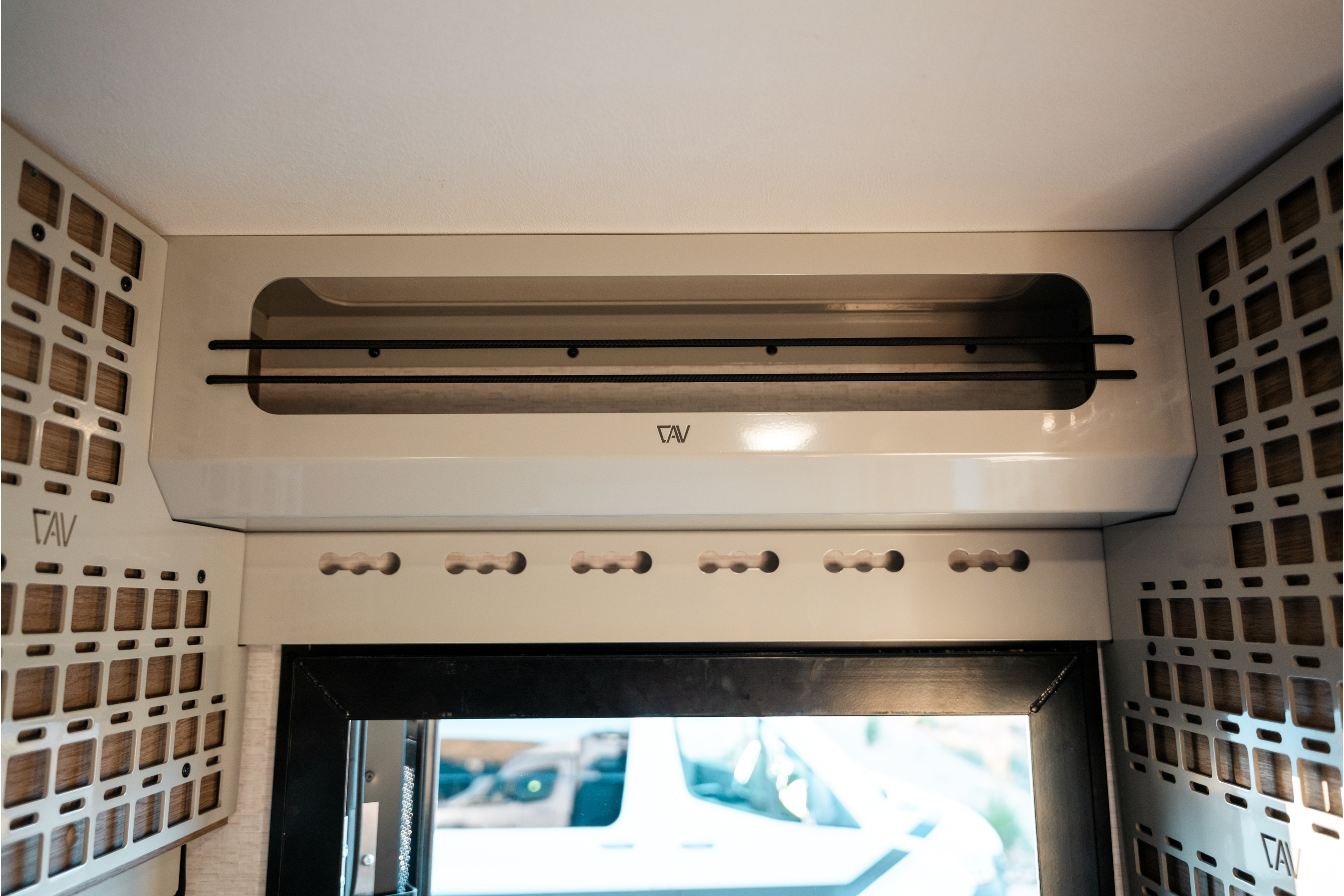 beige Ekko Doorway Upper Cabinet by CAV mounted above winnebago ekko sprinter van entry with ventilated side panels and cabinet with bungees