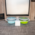 Revel dog bowl carrier with two collapsible bowls on van floor by cabinet