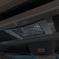 Overhead storage net installed on the ceiling of a van interior