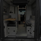 Revel floor mattress laid out between benches in the rear of a van interior setup for camping.
