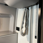 Revel bed harness cover in grey fabric hanging along interior van wall