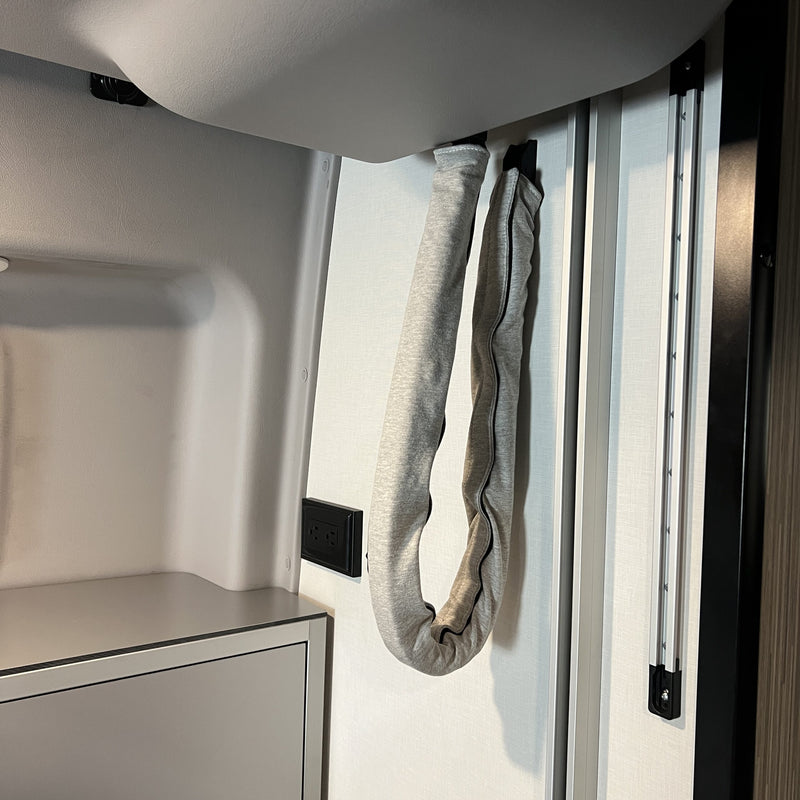 Revel bed harness cover in grey fabric hanging along interior van wall