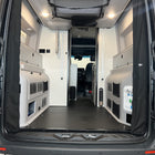 Revel bed harness cover installed in rear van interior with folded sleeping platform and storage compartments.