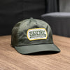 Green Talon Chatsworth Hat with mesh back and logo patch on wood surface